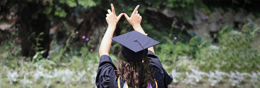 Graduate raising arms and forming Western "W"