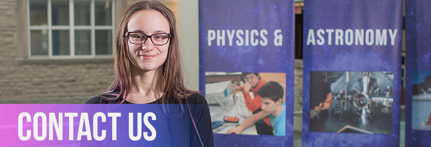 Person in front of Physics and Astronomy Banners at open house